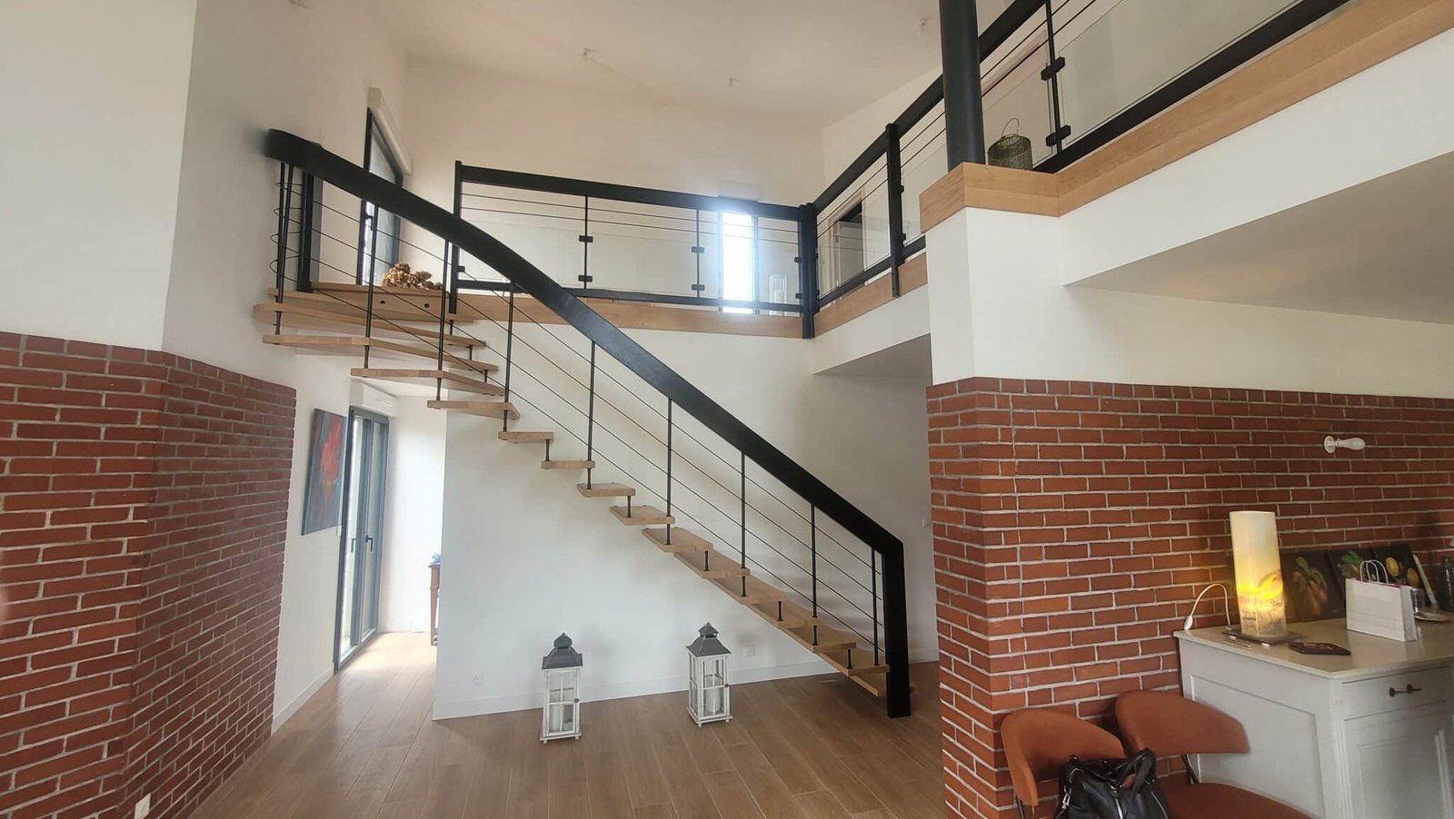 Un espace intérieur moderne avec un escalier en bois et métal noir.