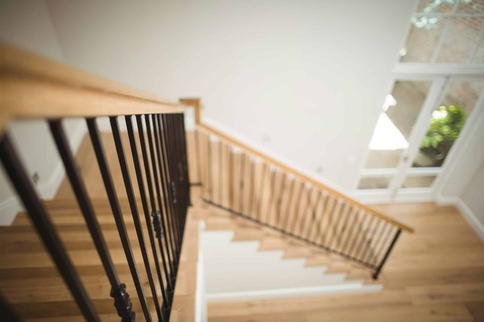 Escalier avec rampe en bois donnant sur un espace ouvert et lumineux