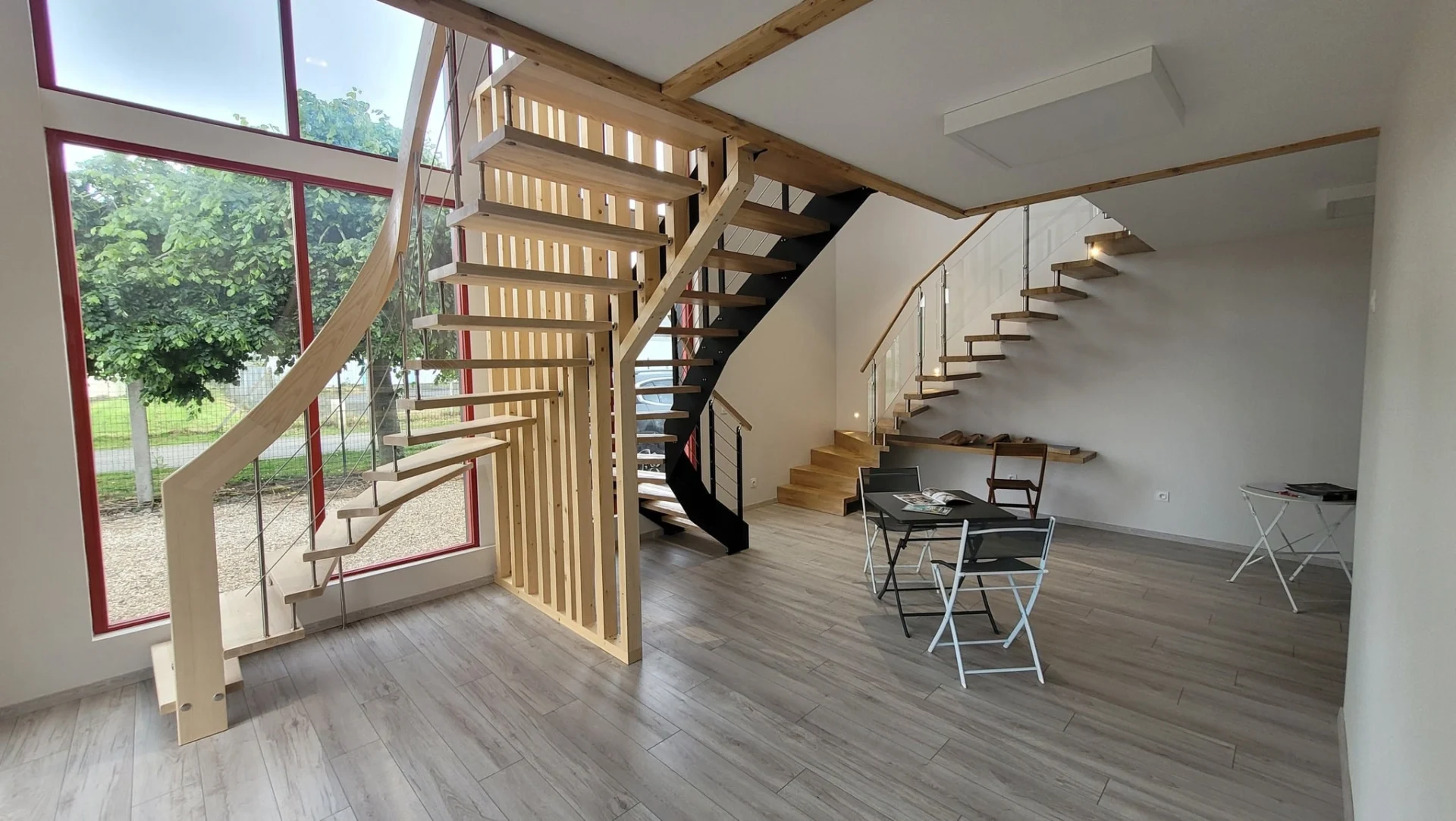 Escalier en bois à double volée avec claustra bois dans un local vitré