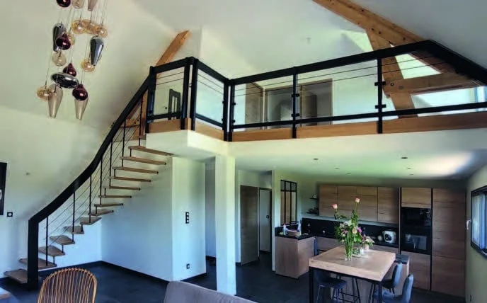 Escalier bois et métal noir menant à une mezzanine au-dessus de la cuisine