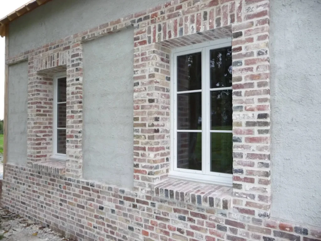 Fenêtres blanches posées dans une façade en briques