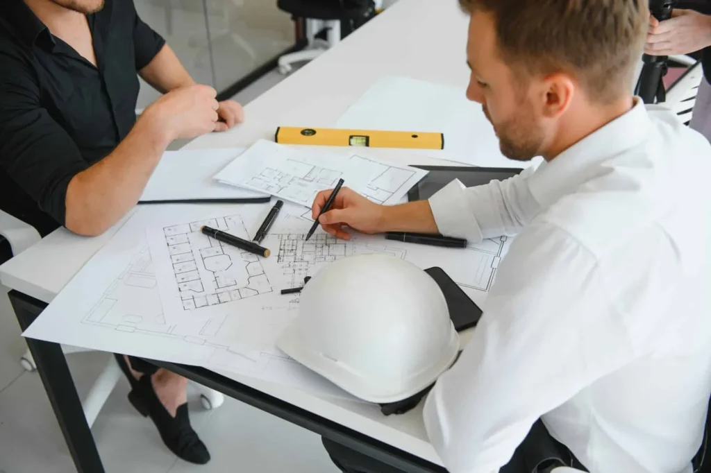 Architectes étudiant des plans sur une table