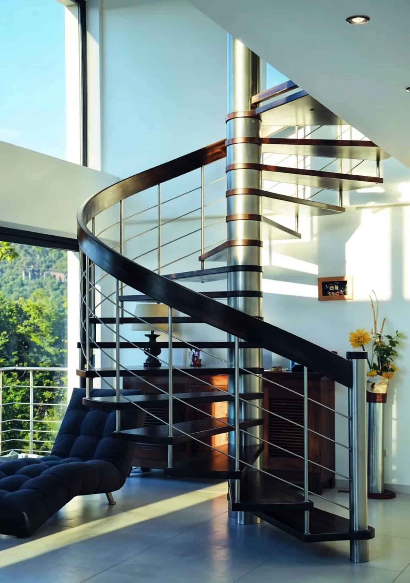 Escalier hélicoïdal métal et bois dans un séjour vitré