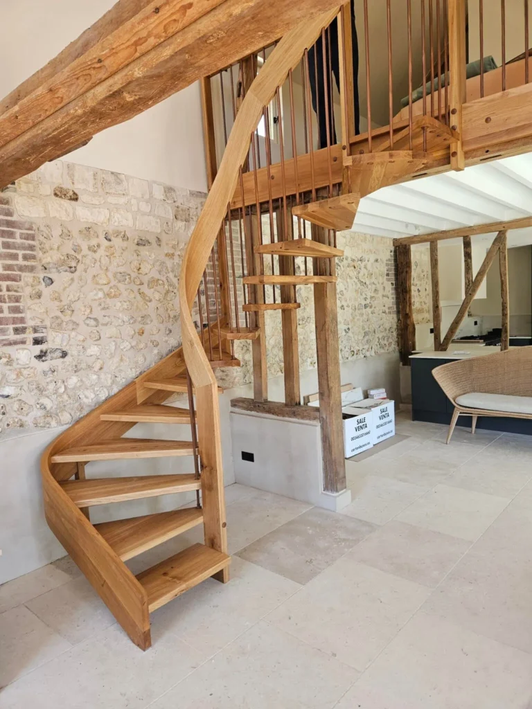 Escalier hélicoïdal en chêne menant à une mezzanine