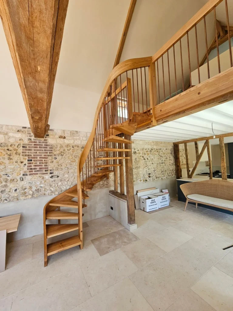 Escalier hélicoïdal en chêne sous charpente apparente