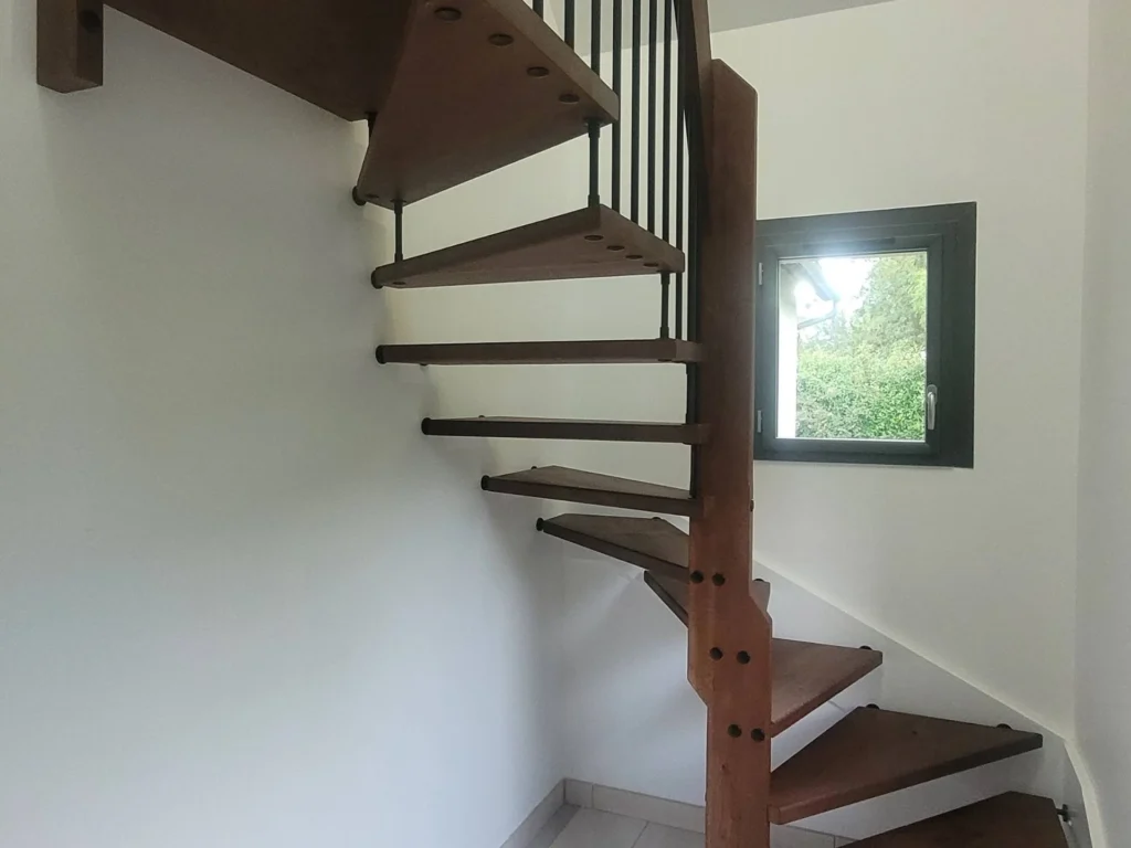Escalier droit en bois clair à barreaux métal dans une cuisine