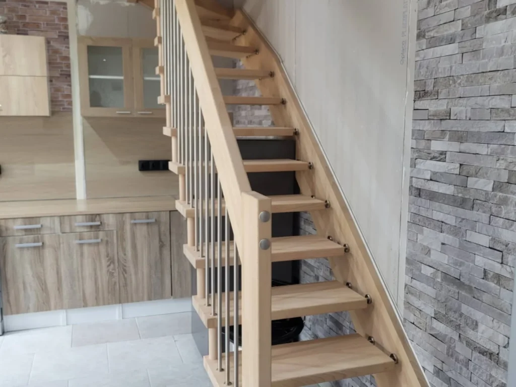 Escalier droit en bois clair à barreaux métal dans une cuisine