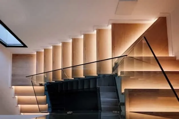Escalier en bois aux marches éclairées par LED, garde-corps en verre