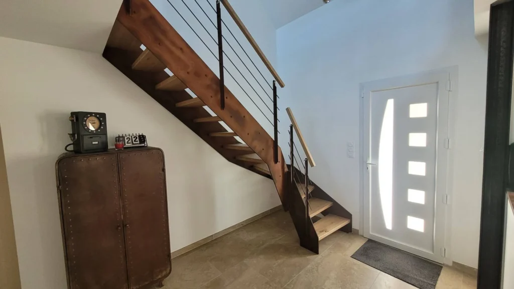 Escalier en bois foncé et garde-corps métal dans une entrée
