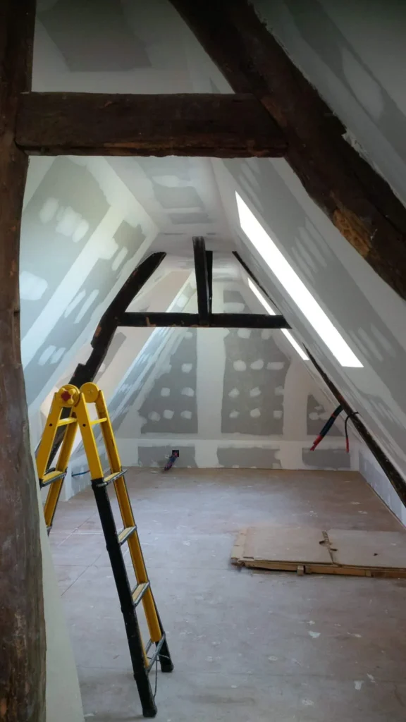 Combles en cours d'aménagement sous la charpente, fenêtre de toit