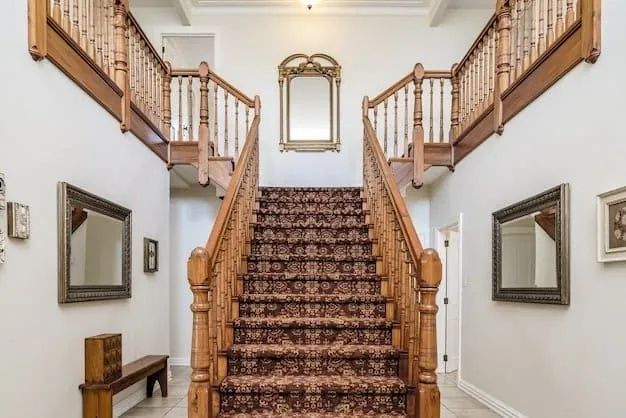 Escalier double en bois avec balustres tournés dans un hall