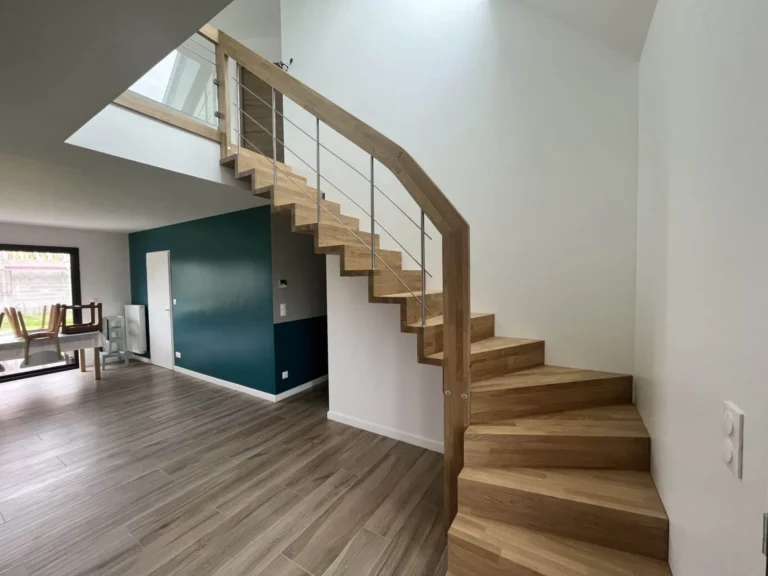 Escalier deux quarts tournants en bois clair dans une maison neuve