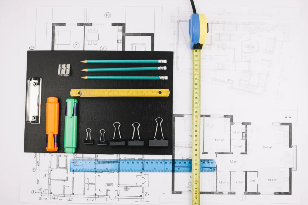 Plans d'architecte, mètre ruban et outils de dessin pour concevoir un escalier sur mesure