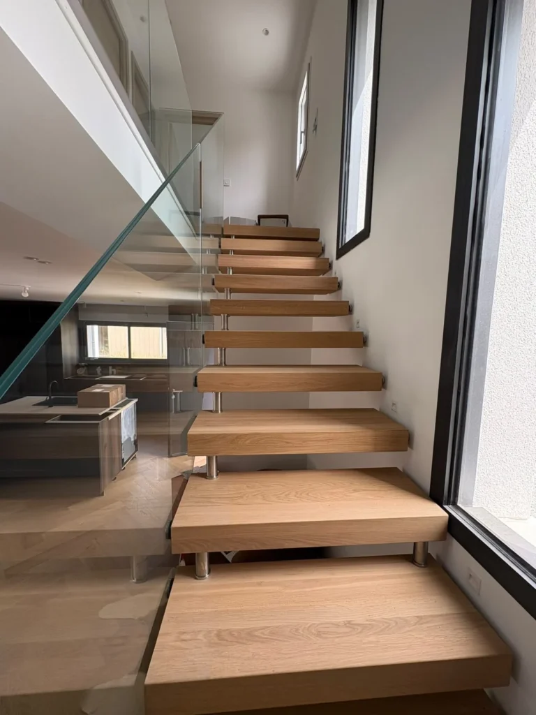 Escalier droit à marches en bois sur structure métal et garde-corps en verre