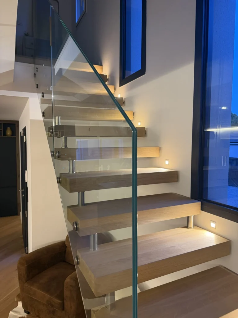 Escalier suspendu à marches éclairées et garde-corps en verre