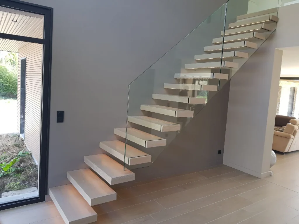 Escalier suspendu en bois clair avec garde-corps en verre